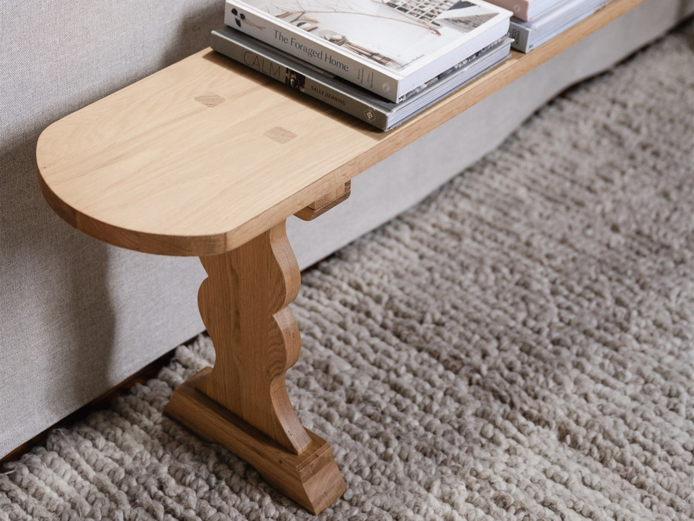 The versatile french bench with books on it at the end of a couch