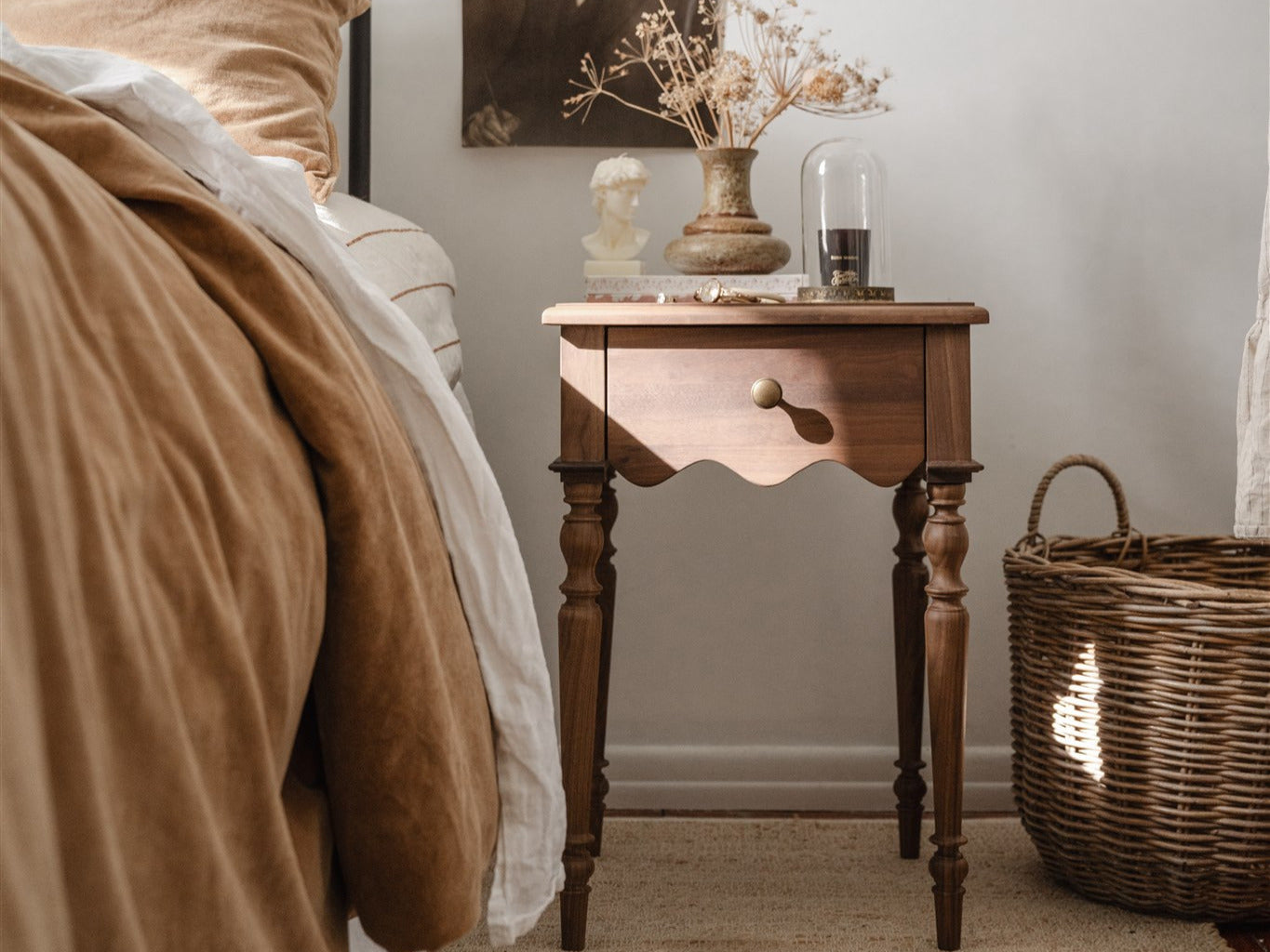 Evie Bedside Table in Walnut with a vase, candle and book on it emphasising the rule of three. 